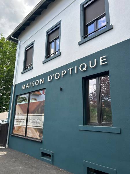 Vitrine d’un opticien avec enseigne en lettres en relief MAISON D’OPTIQUE — Création d’enseignes lumineuses élégantes et durables, adaptées à l’identité visuelle des professionnels de la signalétique extérieure dans le Grand Est.