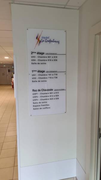 Plaque intérieure en Altuglas avec entretoises indiquant les unités d’hébergement et étages – signalétique intérieure hospitalière dans le Bas-Rhin.